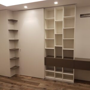 Zona living con porta scorrevole e libreria